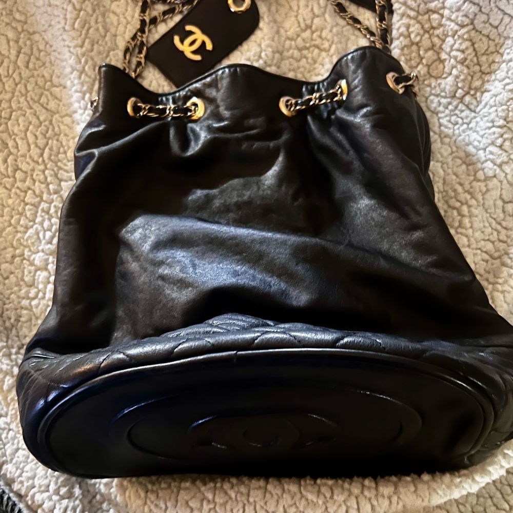 Black leather quilted bucket with double chain straps.  Exterior in GC